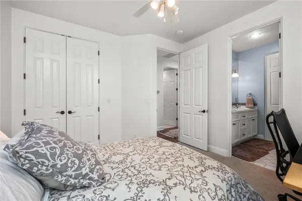 a bedroom with a bed a chair and a chandelier