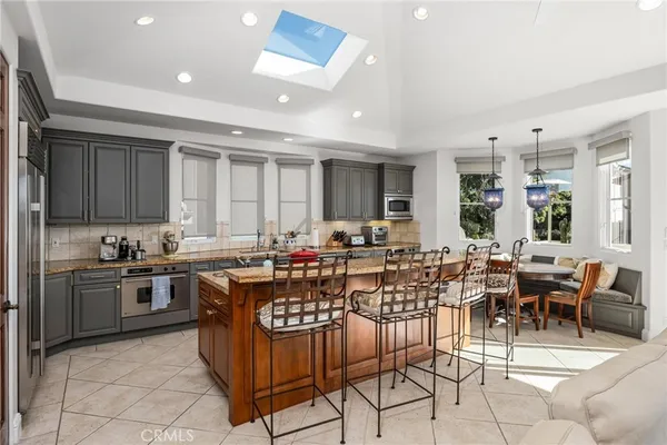 a kitchen with stainless steel appliances granite countertop a sink and a refrigerator