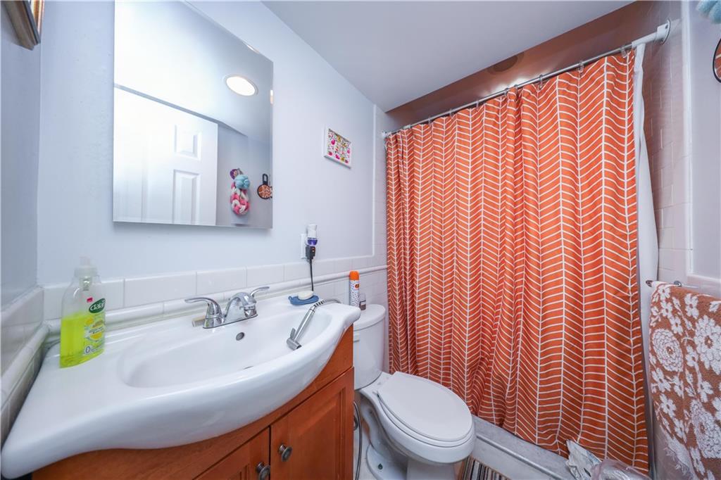 196 Quentin Road Brooklyn, NY 11223 - Photo 6 of 29 a bathroom with a sink and mirror with toilet