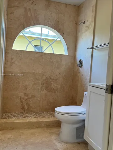 a bathroom with a toilet a sink and mirror