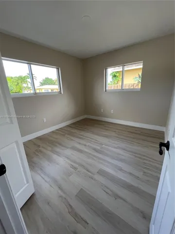 a view of a hallway with wooden floor and stairs