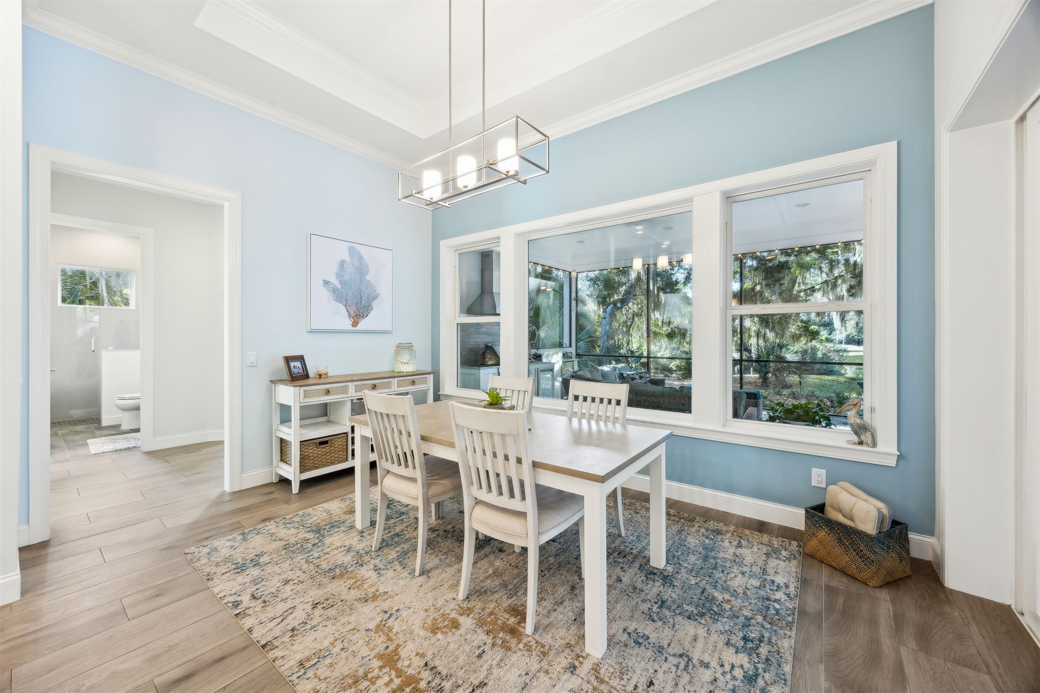 96029 Brady Point Road Fernandina Beach, FL 32034 - Photo 17 of 61 a dining room with wooden floor a chandelier a glass table and chairs