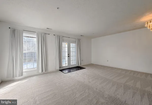 a view of an empty room with windows and closet