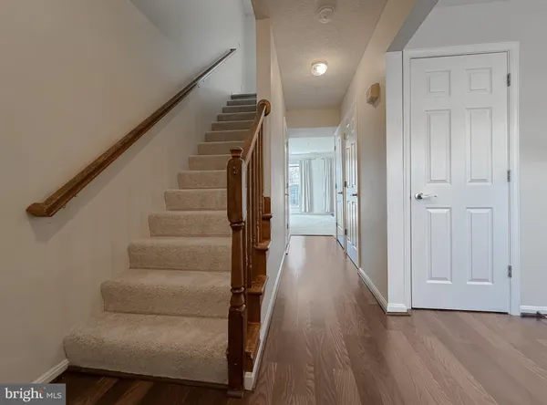 a view of entryway and hall with wooden floor
