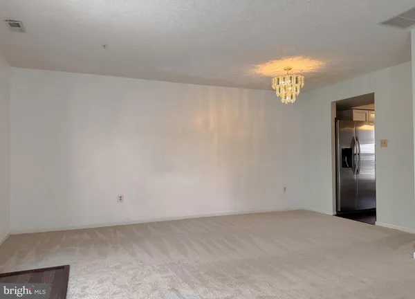 an empty room with a chandelier fan