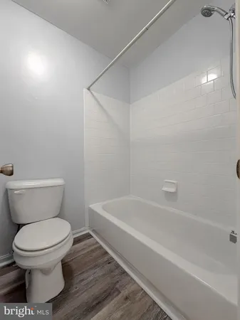a white toilet sitting next to a bath tub