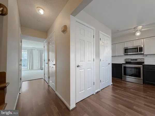 a view of a kitchen with wooden floor and electronic appliances