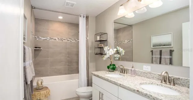 a bathroom with a granite countertop tub sink and mirror