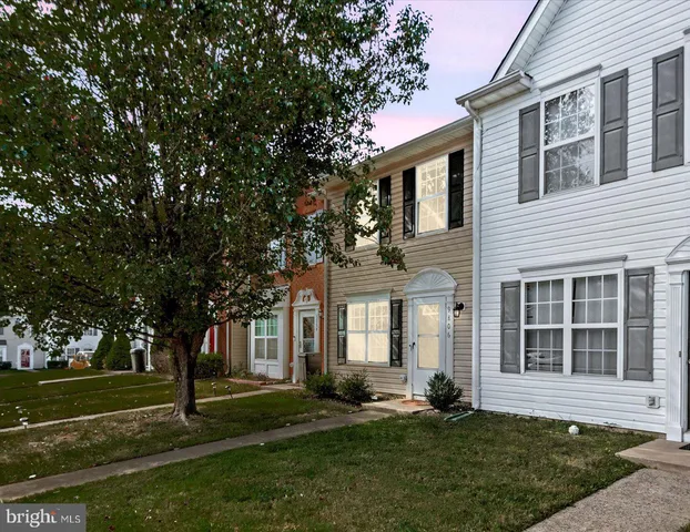 front view of a brick house with a yard