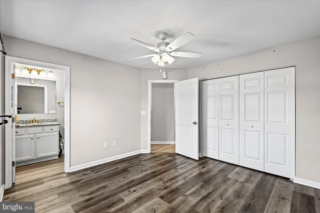 an empty room with a mirror and a ceiling fan