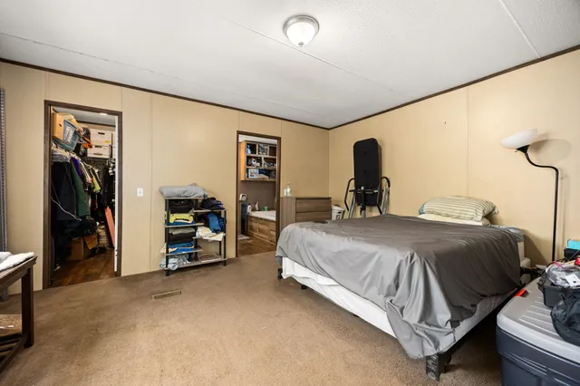 a bed room with a bed and a chair