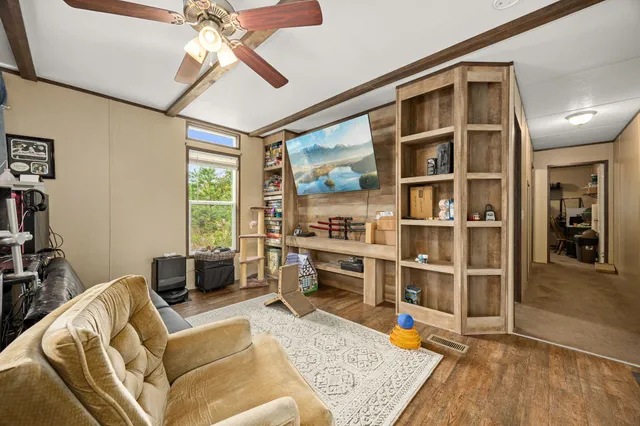 a living room with furniture cabinets and a window