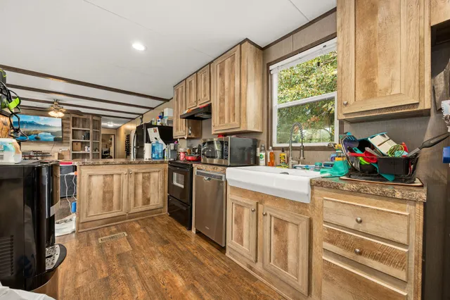 a kitchen that has a lot of white cabinets and stainless steel appliances