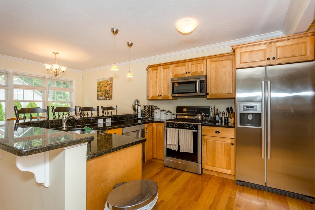 17 Endicott Street, Unit 17 Canton, MA 02021 - Photo 4 of 18 a kitchen with stainless steel appliances granite countertop a sink a stove and a refrigerator