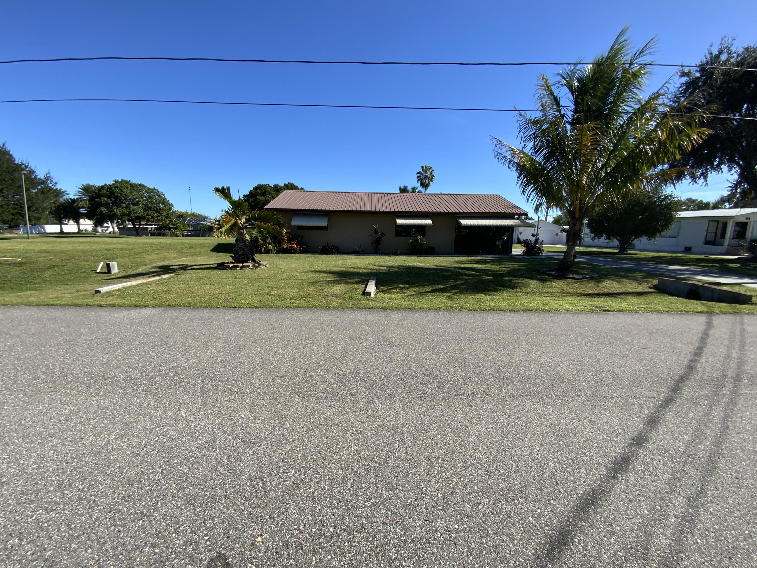 1095 Chobee Loop Okeechobee, FL 34974 - Photo 5 of 46 a view of a house with a yard and large trees