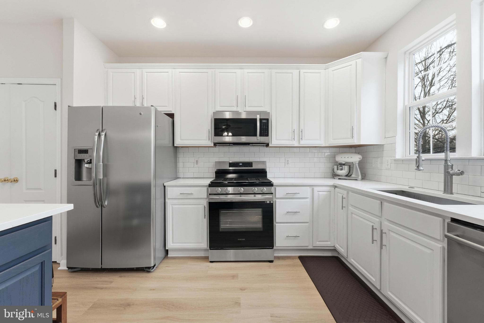 13993 Sawteeth Way Centreville, VA 20121 - Photo 14 of 44 a kitchen with a stove a sink and a refrigerator