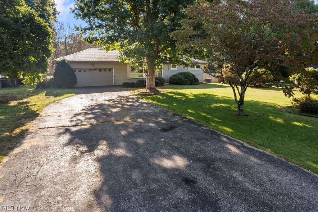 11363 Dupont Road Washington, WV 26181 - Photo 28 of 42 Single-story residence featuring a two-car garage, mature trees, and a sloped lawn