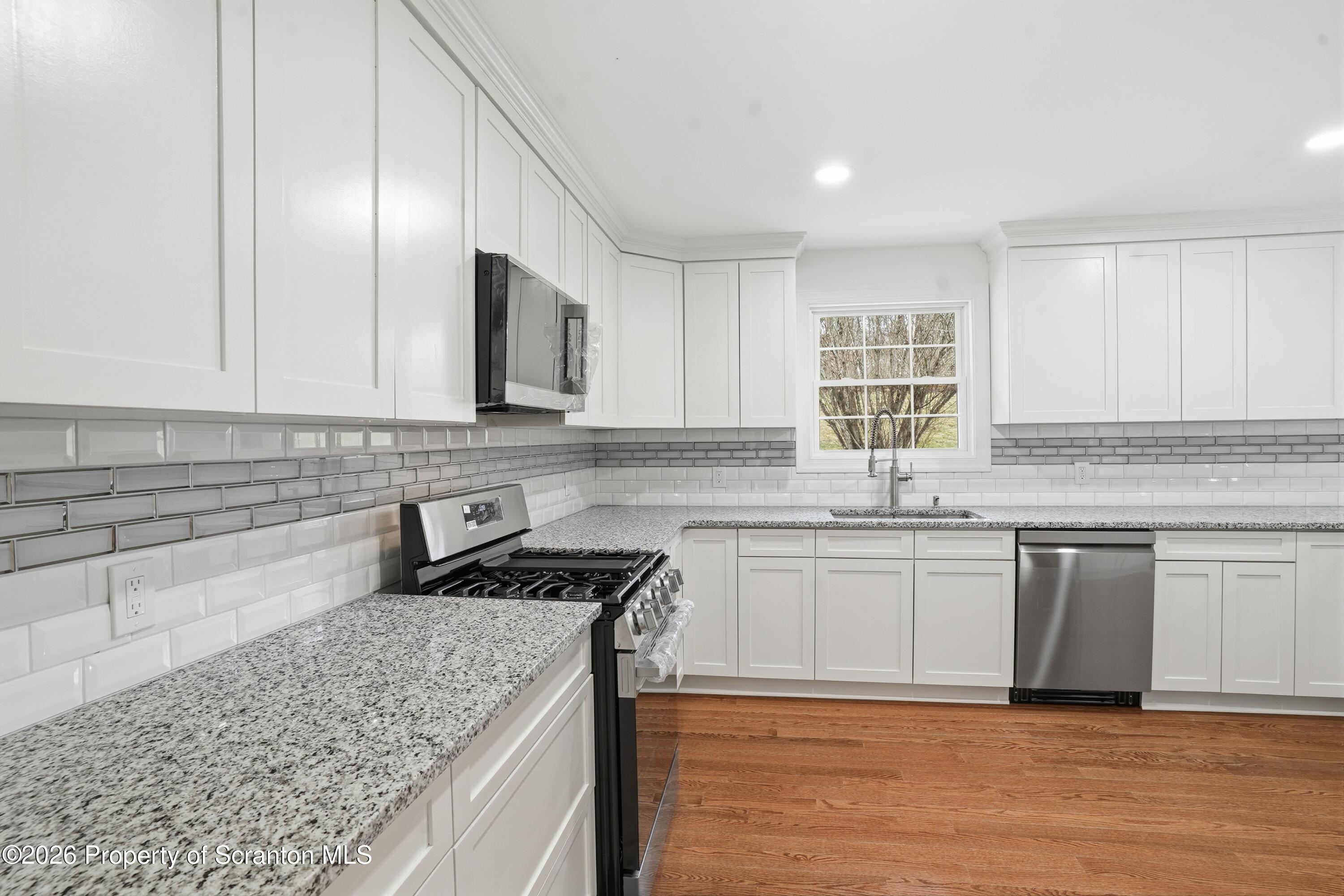 16204 Highway 407 Factoryville, PA 18419 - Photo 40 of 74 a kitchen with stainless steel appliances granite countertop a sink stove and cabinets