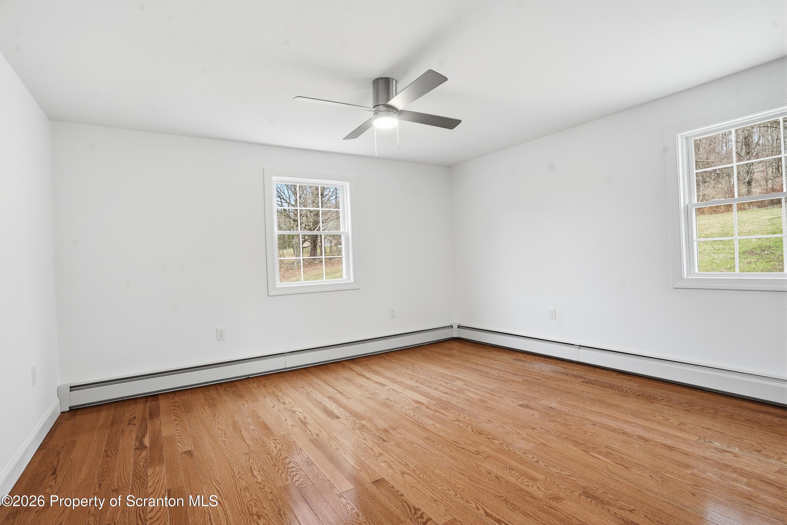 16204 Highway 407 Factoryville, PA 18419 - Photo 48 of 74 an empty room with wooden floor and windows