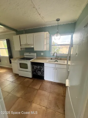 a kitchen with a sink a stove a microwave and cabinets