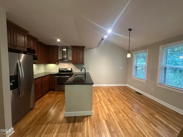 a kitchen with granite countertop a refrigerator stove top oven and sink
