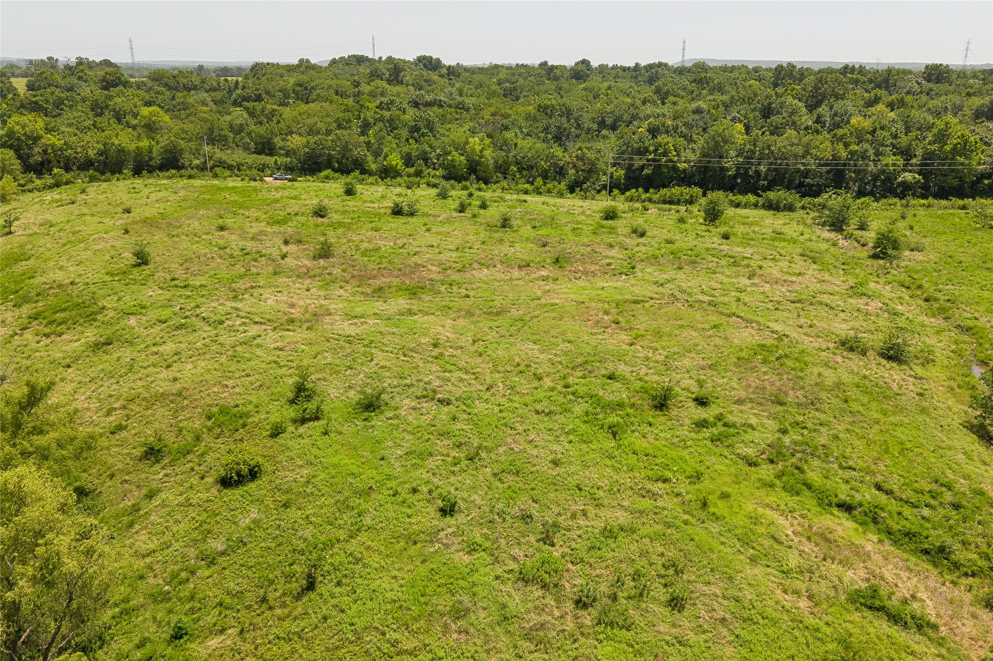 2 West Fern Mountain Road Muskogee, OK 74401 - Photo 37 of 55 Expansive grassy terrain with scattered shrubs, bordered by a dense tree line