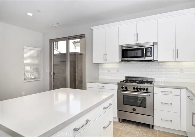 a kitchen with white cabinets stainless steel appliances and sink