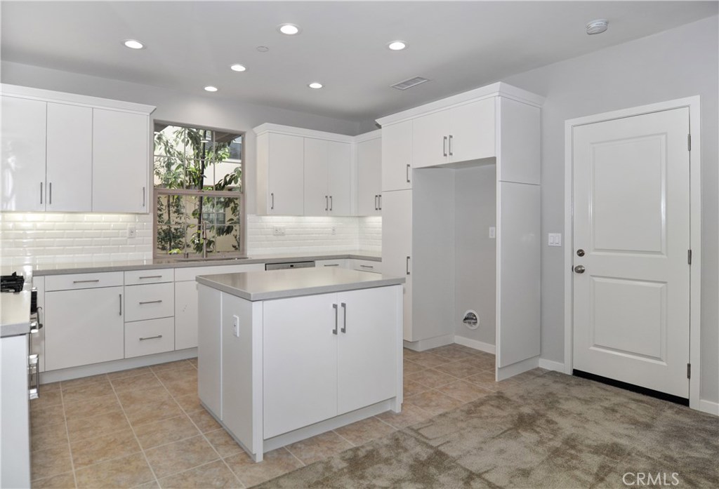 123 Quiet Grove Irvine, CA 92618 - Photo 4 of 16 a kitchen with white cabinets and refrigerator