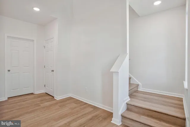 a view of empty room with wooden floor and windows