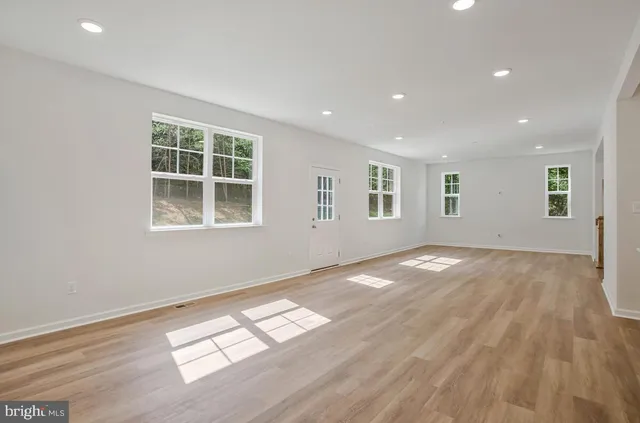 a kitchen with a sink dishwasher a stove and white cabinets with wooden floor