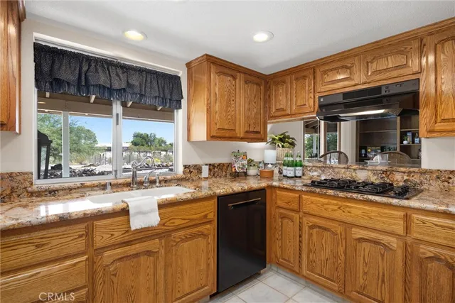 a kitchen with stainless steel appliances granite countertop a sink stove and cabinets
