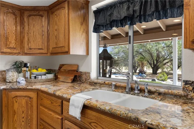 a kitchen with sink a window and cabinets