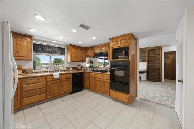 a kitchen with stainless steel appliances granite countertop a refrigerator and a stove top oven