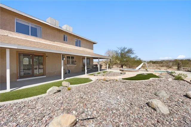 a view of a house with a swimming pool and sitting area
