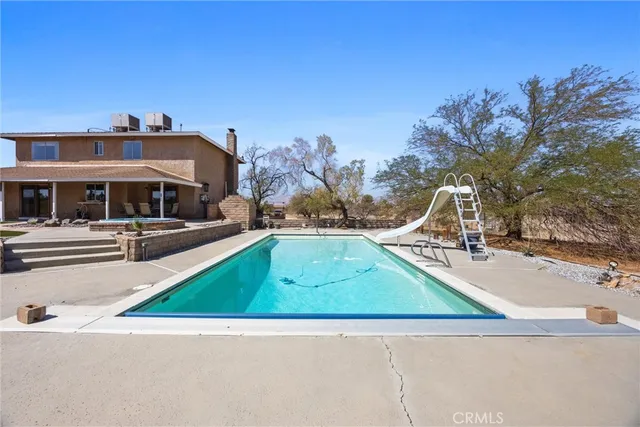 a view of swimming pool with chairs and lake view