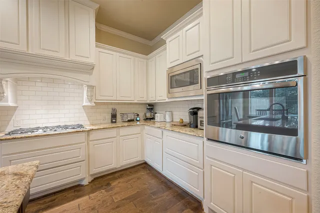 a kitchen with granite countertop white cabinets and white appliances