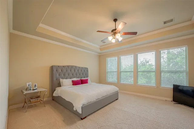 a bedroom with a large bed and a chandelier