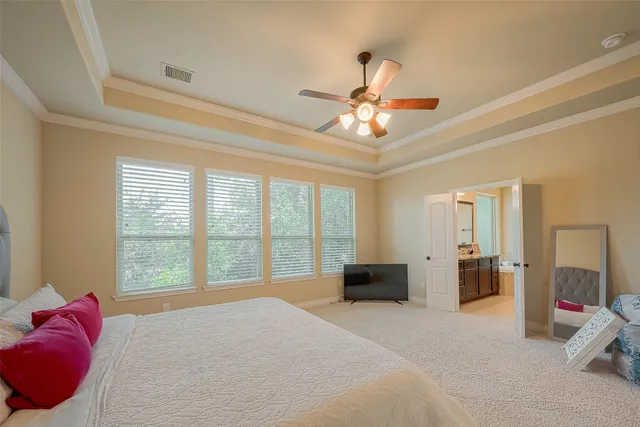 a spacious bedroom with a bed and a chandelier