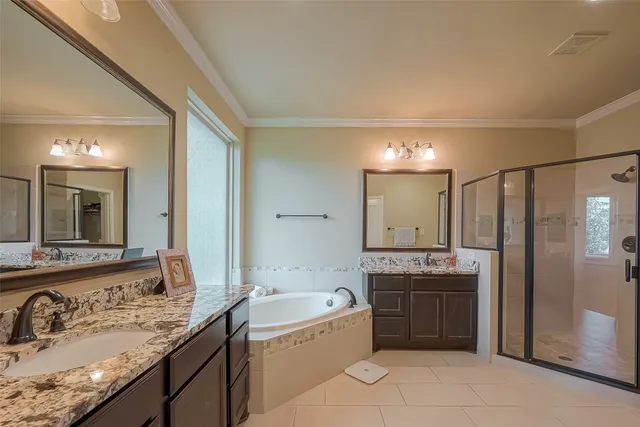 a spacious bathroom with a granite countertop sink mirror and a bathtub
