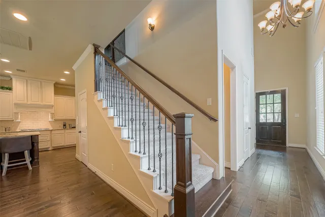 a view of a hallway with wooden floor and staircase