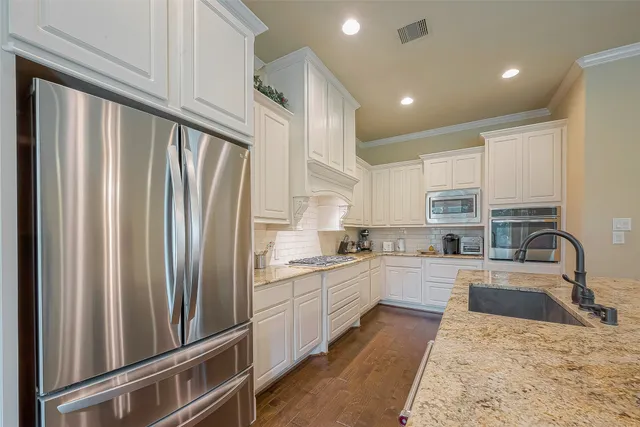 a kitchen with stainless steel appliances granite countertop a refrigerator sink and cabinets