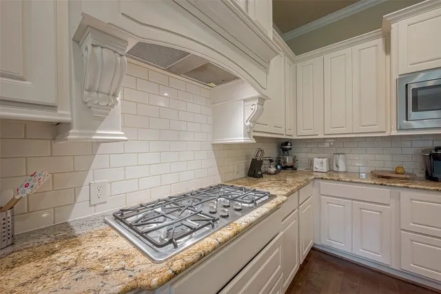 a kitchen with white cabinets and appliances