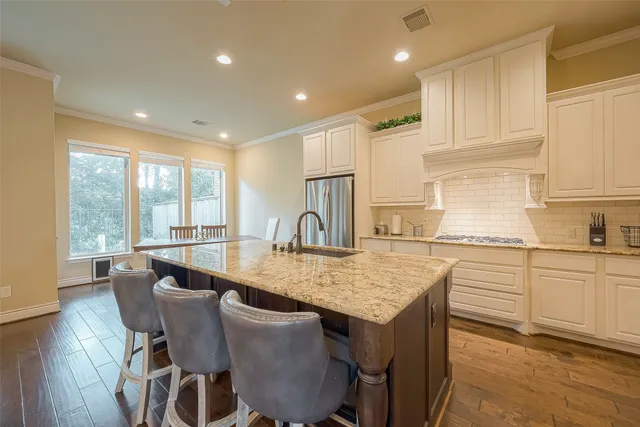 a kitchen with granite countertop white cabinets and wooden floor
