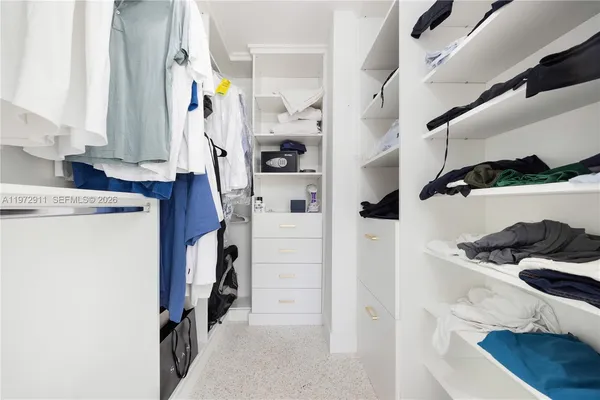 a view of walk in closet with clothes and shoes