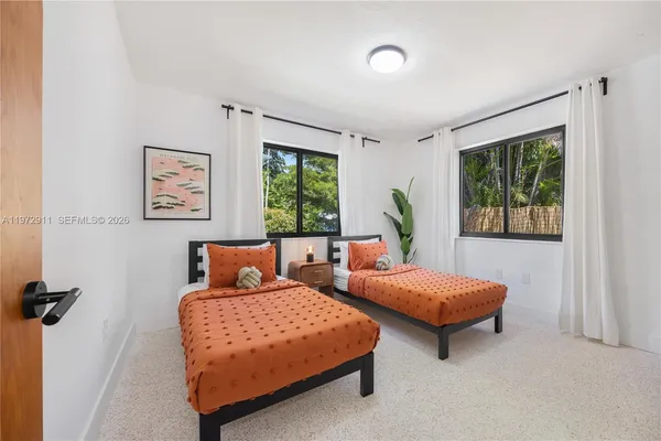 a bedroom with two beds and a window