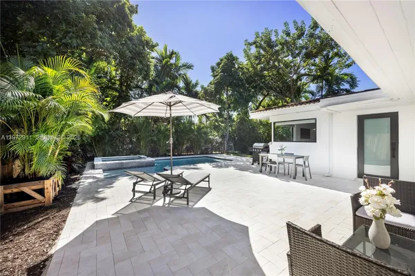 a view of a patio with chairs and table under an umbrella