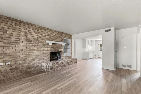 a view of a livingroom with wooden floor and a fireplace