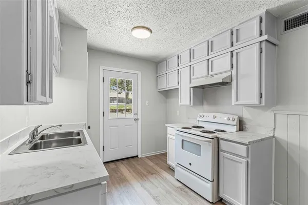 a kitchen with white cabinets and white appliances
