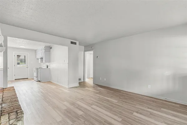 a view of a room with wooden floor and white walls