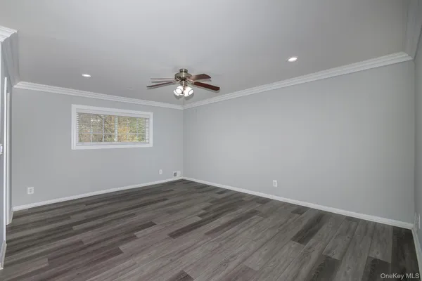 a view of an empty room with wooden floor